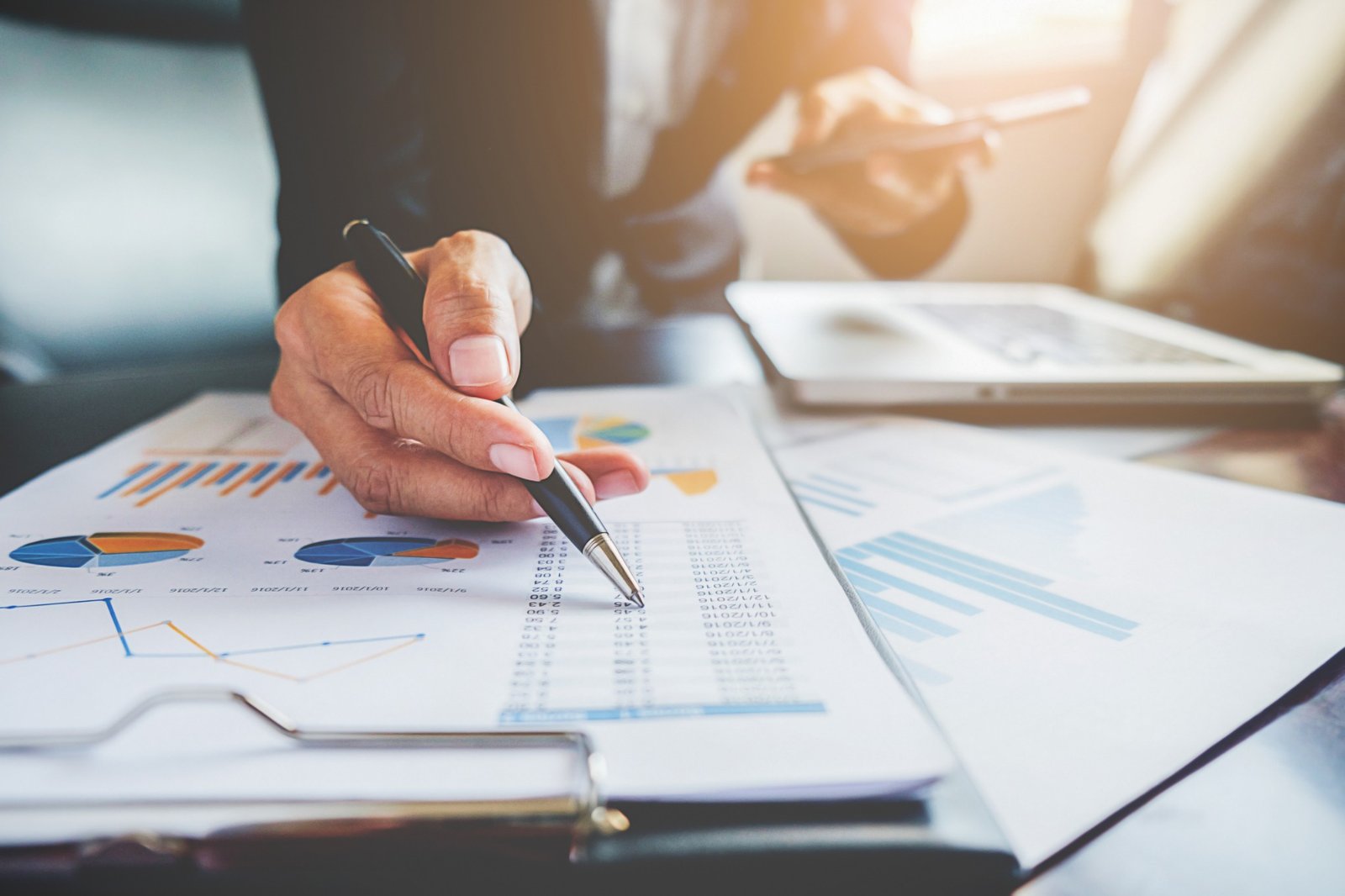 Profissional analisando gráficos e relatórios financeiros.